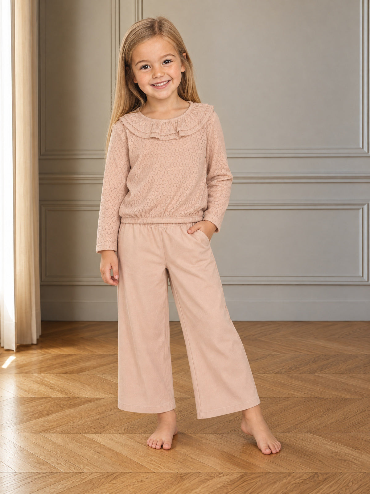 Girl wearing a long-sleeved cotton jersey top with a ruffled collar, ribbed cuffs, and elastic hem.